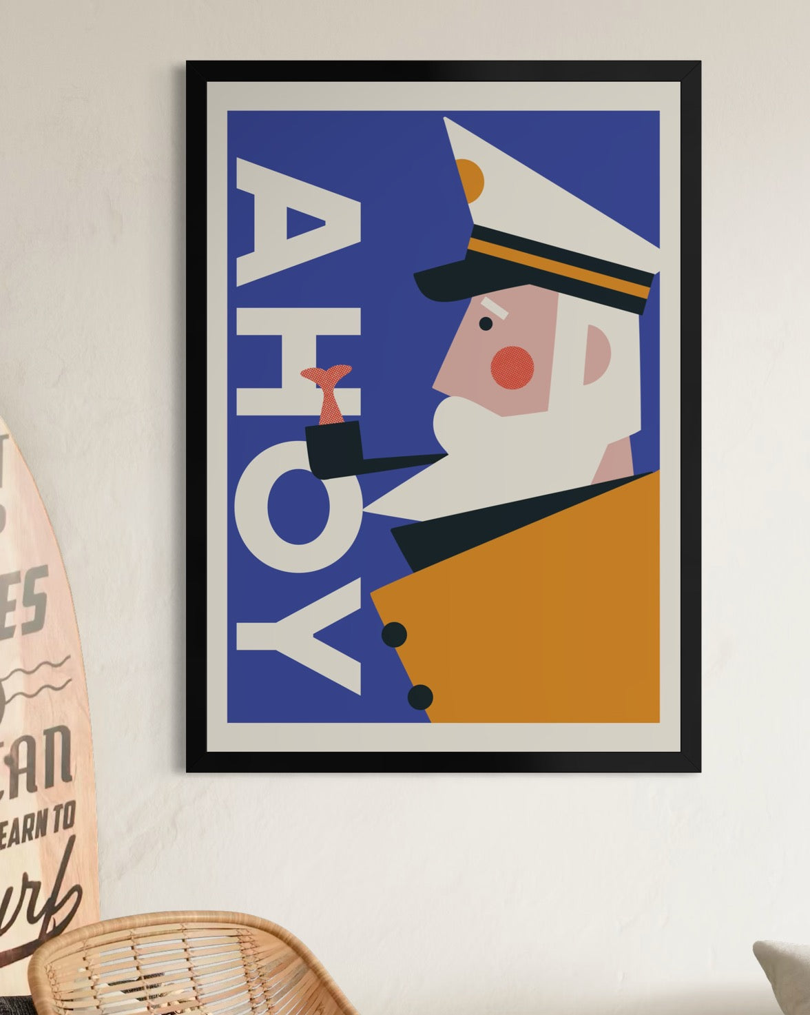 Retro framed poster with a character in a captain's hat and 'AHOY' text on a blue background, displayed on a wall.