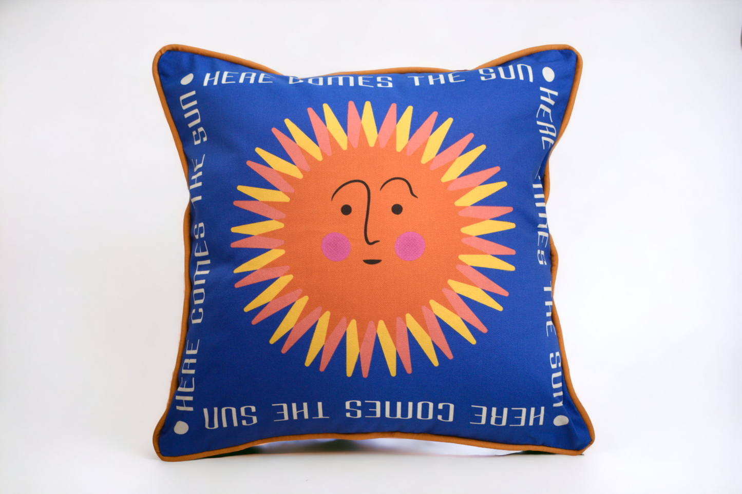 Retro sun cushion with a blue background and golden piping around the edge. On the back there is a retro geometric pattern