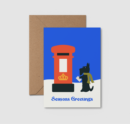 A6 greeting card with a brown kraft envelope  featuring an illustration of a red post box, a black Scottish terrier wearing a green scarf, and the text 'Seasons Greetings' 
